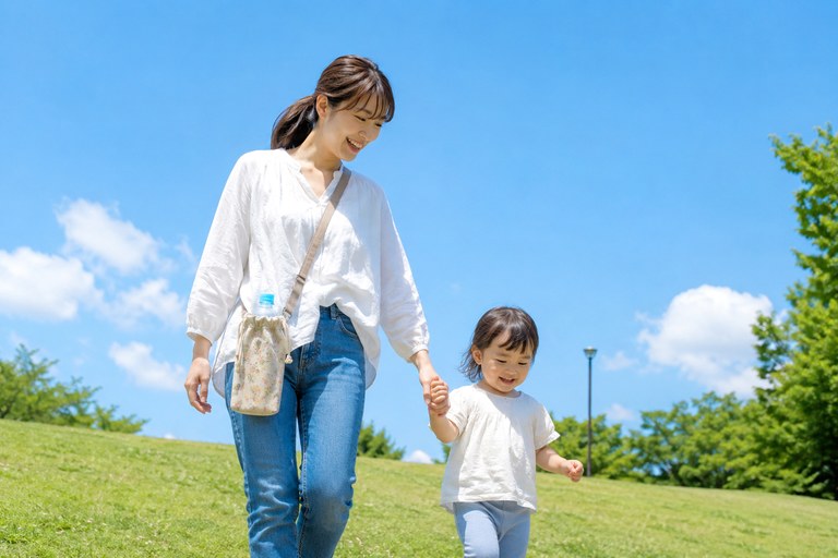 青空の下で親子がおでかけしている様子